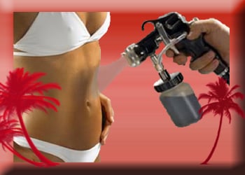 Woman in white bikini receives airbrush spray tan on her abdomen.
